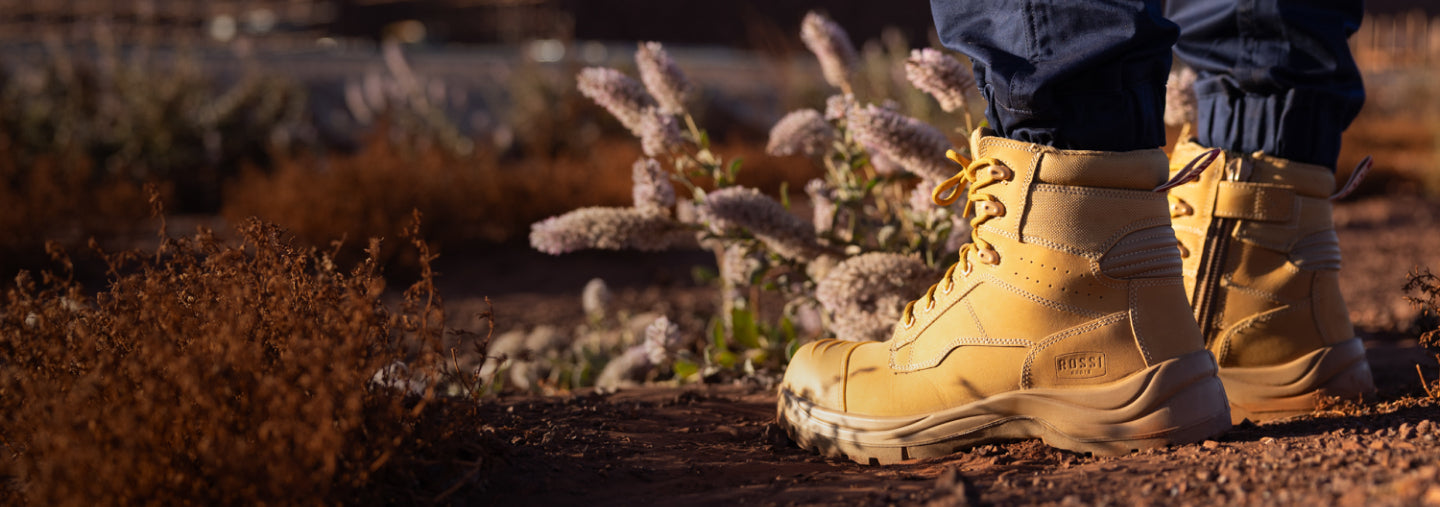 Tan boots standing on a dirt path with blurred natural background