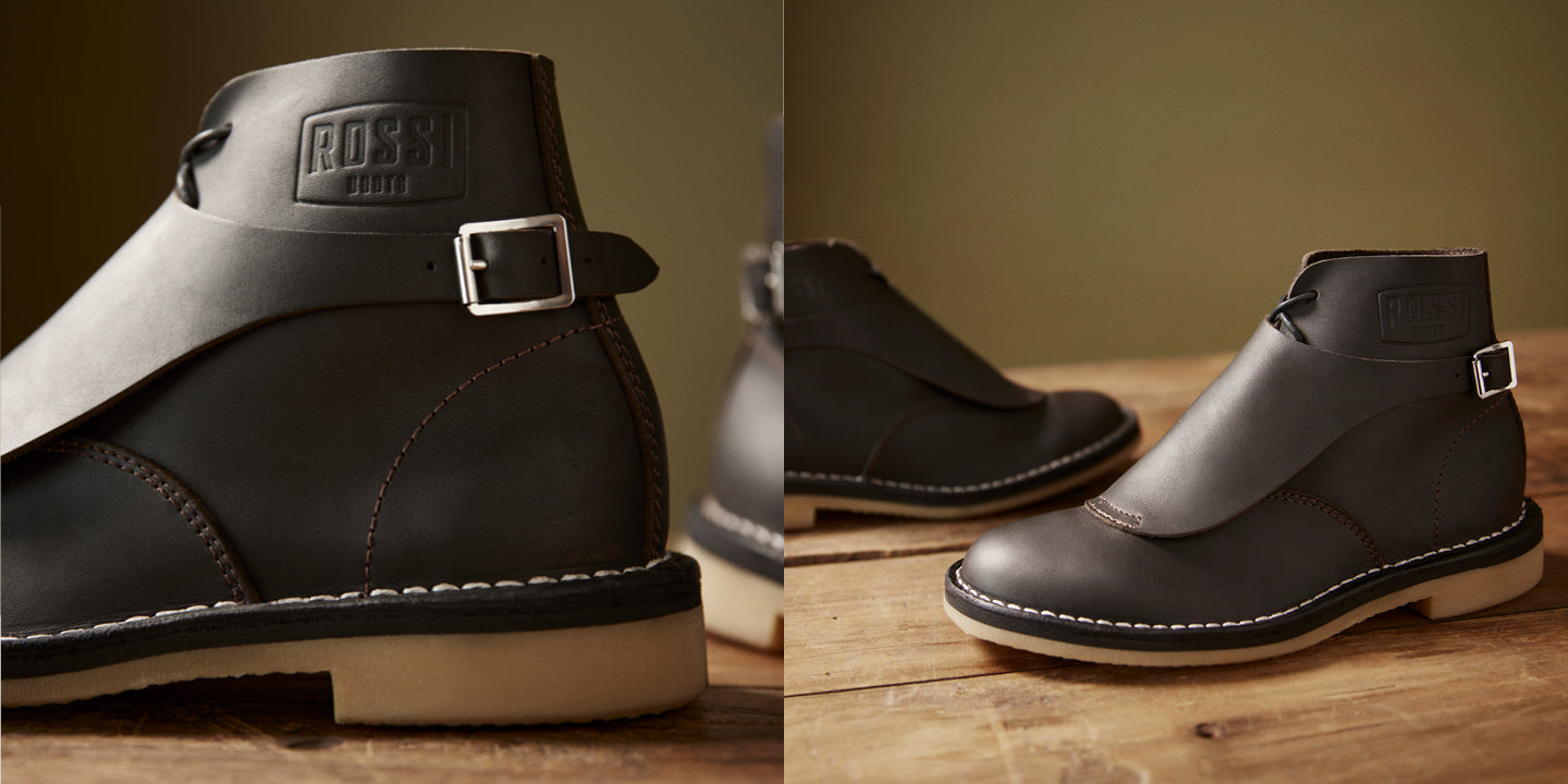 A black leather ankle boot with a strap and buckle, shown in a split-screen close-up and side view on a wooden surface against a warm brown background. The brand name 'ROSSI' is embossed on the heel strap.