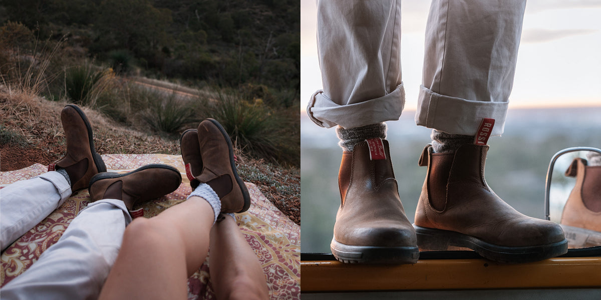 A split-screen lifestyle image showing a pair of brown leather Chelsea boots worn by two people. The left side shows the boots on feet while lying on a blanket outdoors on a hillside.